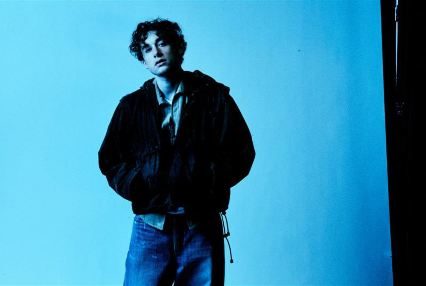 An musician called 'ThxSoMuch' posed in front of a blue backdrop